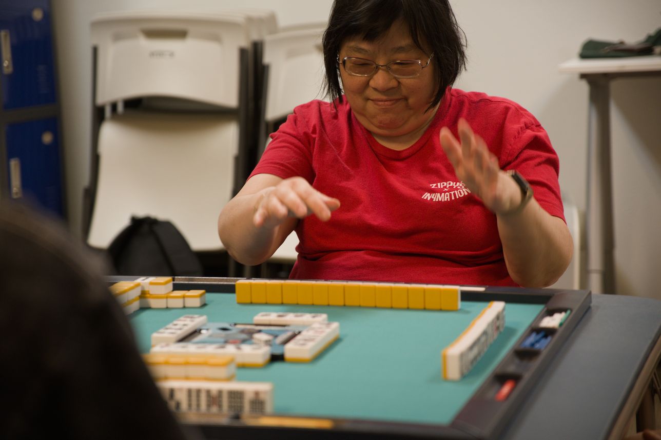 A player happily ponders which tile to discard from their hand.